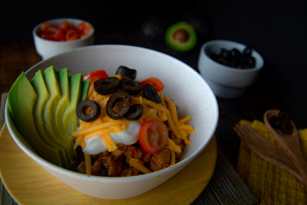 Turkey taco bowl with sour cream cheddar cheese black olives tomato avocado